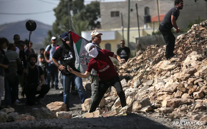 Palestinian protesters hurl stones towards Israeli security forces during clashes following a weekly demonstration against the expropriation of Palestinian land by Israel in the village of Kfar Qaddum, near the West Bank...
