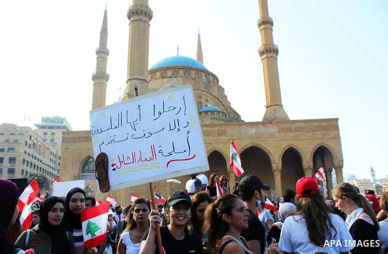 Lebanese demonstrators wave national flags as they take part in a protest against dire economic conditions in Beirut on October 20, 2019. Thousands continued to rally despite calls for calm from politicians and dozens of...