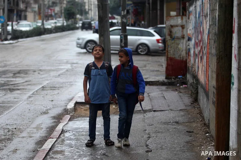 Palestinians walk during a rainy day in Gaza city on October 26, 2019. Photo by Mahmoud Ajjour