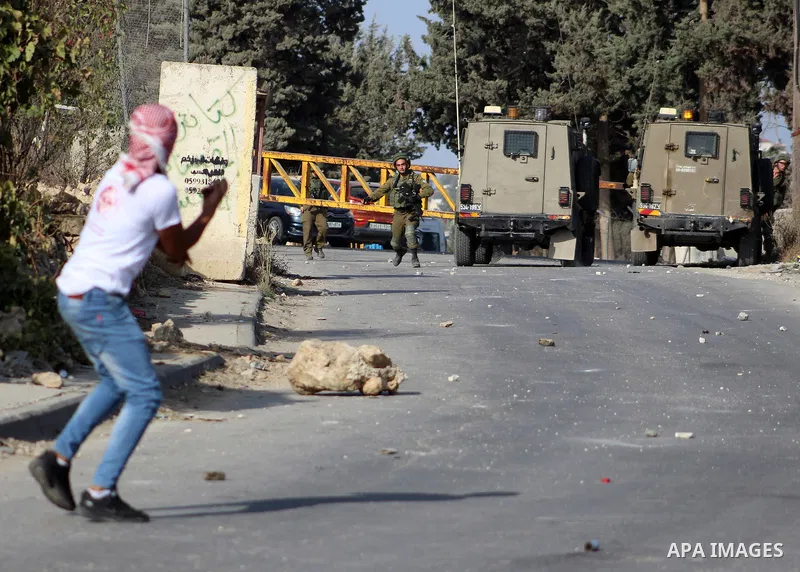 Palestinian protesters hurl stones towards Israeli security forces at al-Arrub refugee camp, north of Hebron in the southern West Bank on November 13, 2019. Photo by Mosab Shawer