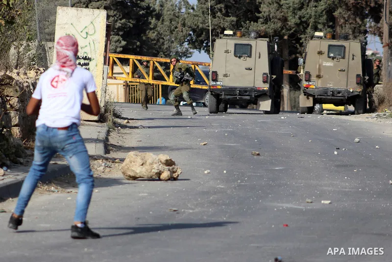 Palestinian protesters hurl stones towards Israeli security forces at al-Arrub refugee camp, north of Hebron in the southern West Bank on November 13, 2019. Photo by Mosab Shawer