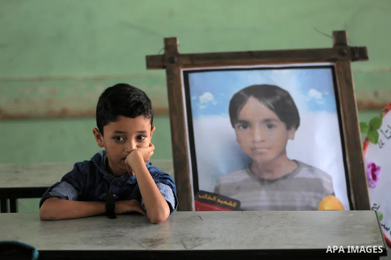 A picture of Palestinian student boy Moath Al Sawarka, who was killed in an Israeli air strike on the Gaza Strip, is seen on his study seat next to his classmates at a school, in Deir al-Balah, central of Gaza Strip on N...