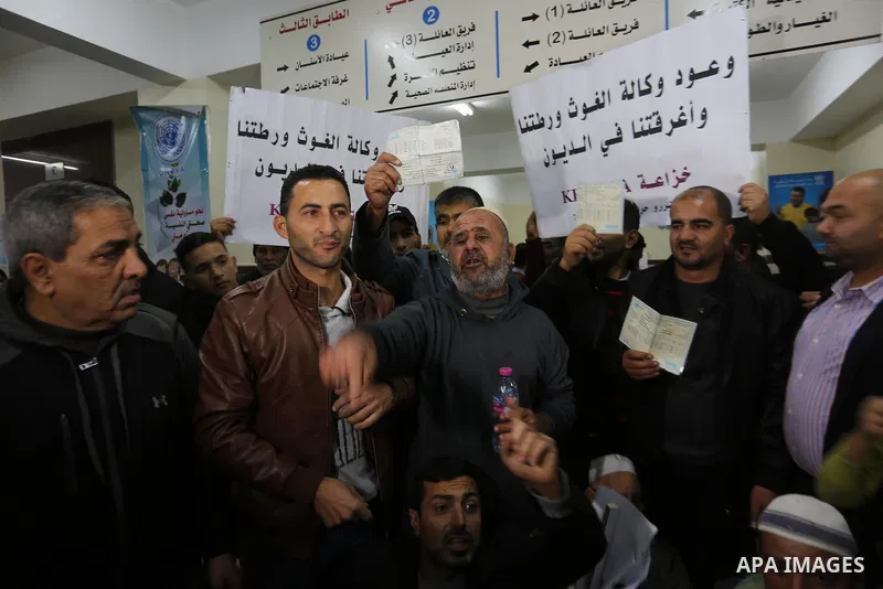 Palestinian owners of houses which were destroyed during the recent Israeli war, take part in a protest demanding repair their houses, at a United Nations-run health center, in Khan Younis in the southern of Gaza strip,...