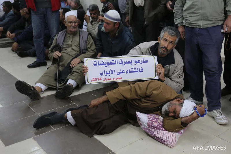 Palestinian owners of houses which were destroyed during the recent Israeli war, take part in a protest demanding repair their houses, at a United Nations-run health center, in Khan Younis in the southern of Gaza strip,...