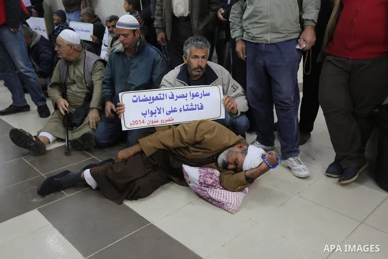 Palestinian owners of houses which were destroyed during the recent Israeli war, take part in a protest demanding repair their houses, at a United Nations-run health center, in Khan Younis in the southern of Gaza strip,...