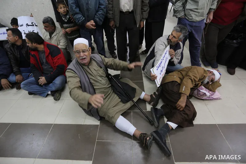 Palestinian owners of houses which were destroyed during the recent Israeli war, take part in a protest demanding repair their houses, at a United Nations-run health center, in Khan Younis in the southern of Gaza strip,...