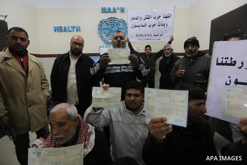 Palestinian owners of houses which were destroyed during the recent Israeli war, take part in a protest demanding repair their houses, at a United Nations-run health center, in Khan Younis in the southern of Gaza strip,...