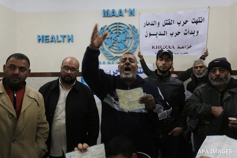 Palestinian owners of houses which were destroyed during the recent Israeli war, take part in a protest demanding repair their houses, at a United Nations-run health center, in Khan Younis in the southern of Gaza strip,...