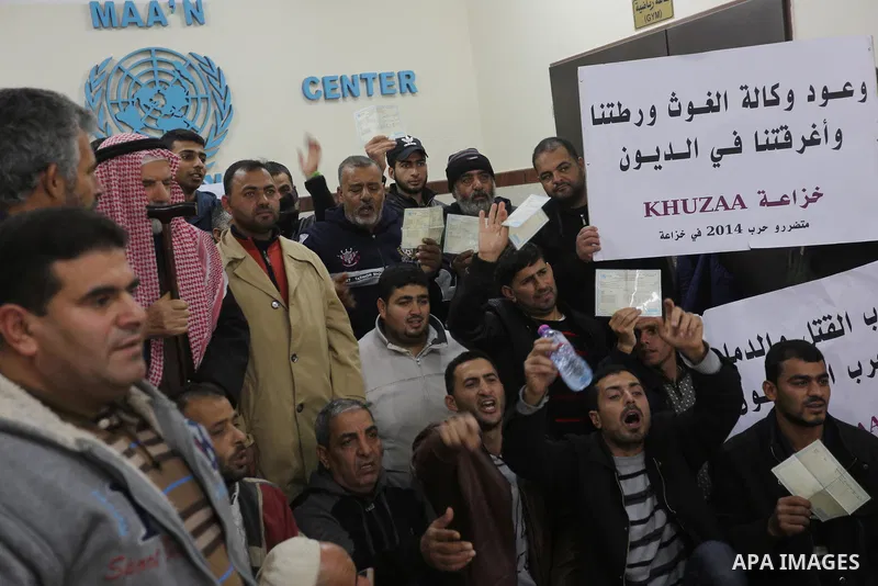 Palestinian owners of houses which were destroyed during the recent Israeli war, take part in a protest demanding repair their houses, at a United Nations-run health center, in Khan Younis in the southern of Gaza strip,...