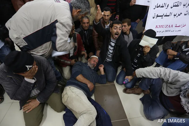 Palestinian owners of houses which were destroyed during the recent Israeli war, take part in a protest demanding repair their houses, at a United Nations-run health center, in Khan Younis in the southern of Gaza strip,...