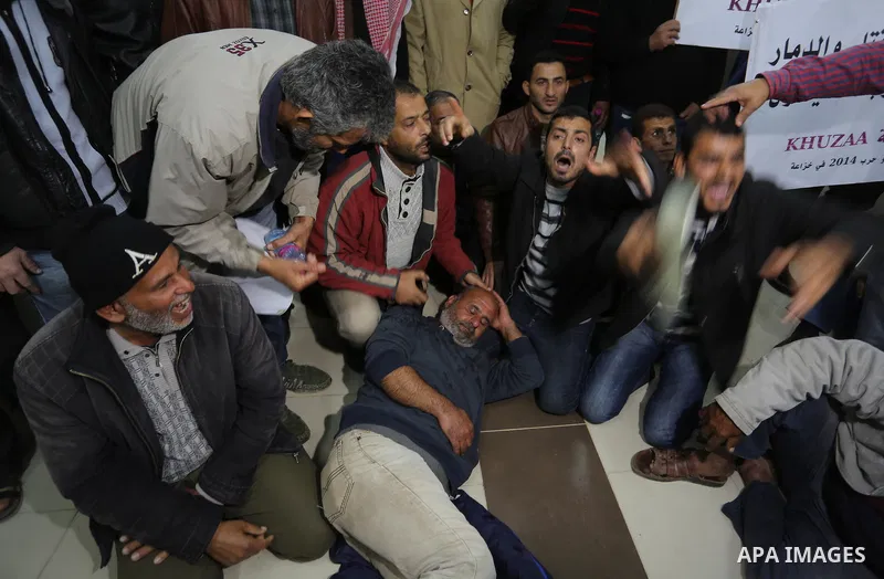 Palestinian owners of houses which were destroyed during the recent Israeli war, take part in a protest demanding repair their houses, at a United Nations-run health center, in Khan Younis in the southern of Gaza strip,...