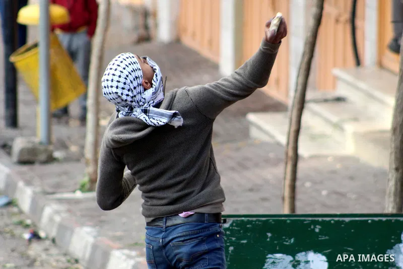 A Palestinian protester hurls a stone towards Israeli security forces during a protest over a U.S. decision on Jewish settlements, in the West Bank city of Hebron on December 9, 2019. Photo by Mosab Shawer