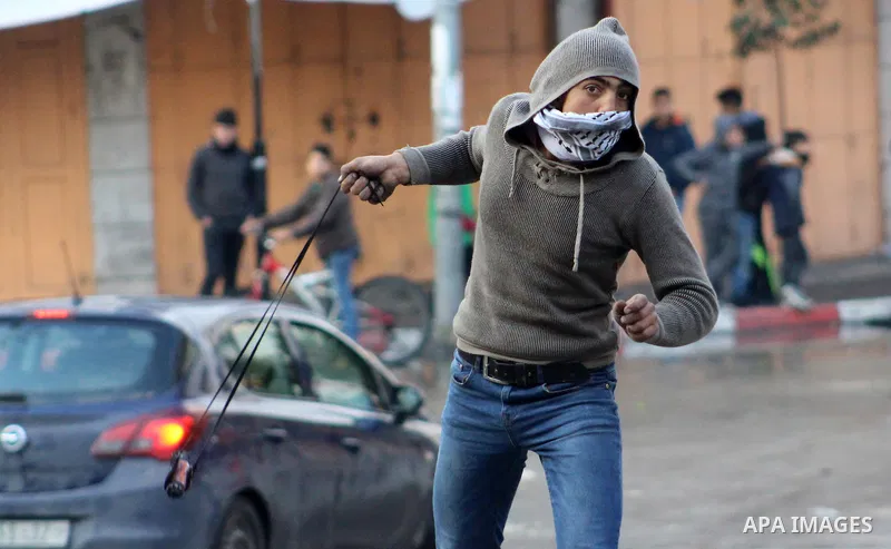 A Palestinian protester hurls a stone towards Israeli security forces during a protest over a U.S. decision on Jewish settlements, in the West Bank city of Hebron on December 9, 2019. Photo by Mosab Shawer