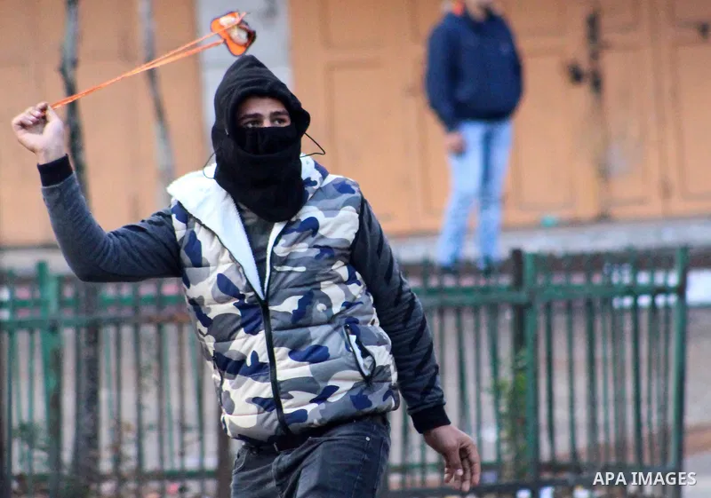 A Palestinian protester hurls a stone towards Israeli security forces during a protest over a U.S. decision on Jewish settlements, in the West Bank city of Hebron on December 9, 2019. Photo by Mosab Shawer