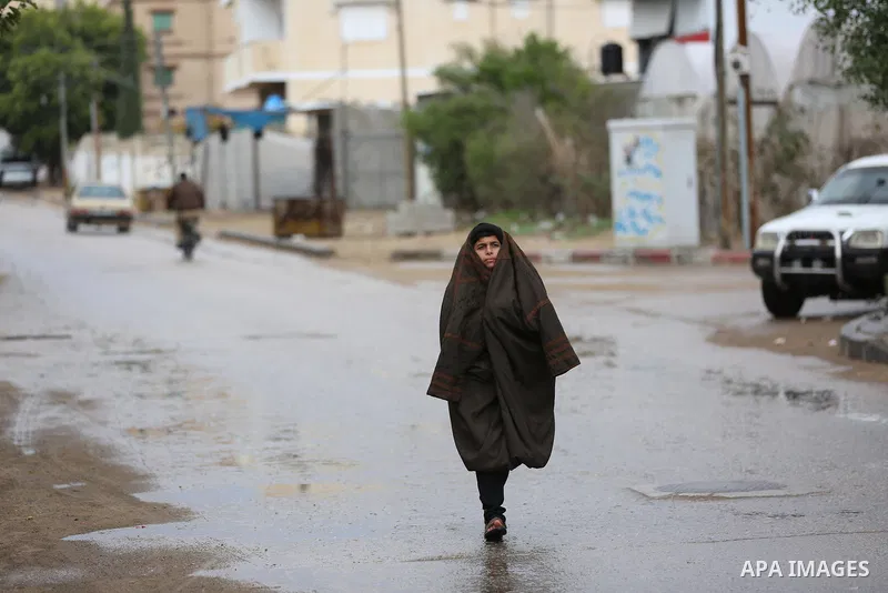 A Palestinian boy walks in a street during a rainy day in Dair Al Balah in the center of Gaza strip on December 15, 2019. Photo by Ashraf Amra