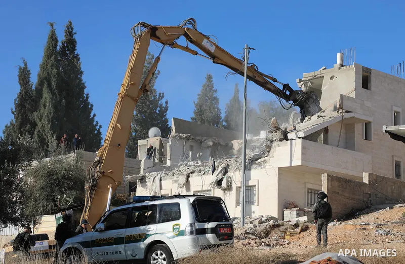 An Israeli bulldozer demolishes a Palestinian building which does not have the Israeli needed permits in the neighbourhood of Issawiya, in the north of Jerusalem, on December 17, 2019. Photo by Muhammed Qarout Idkaidek