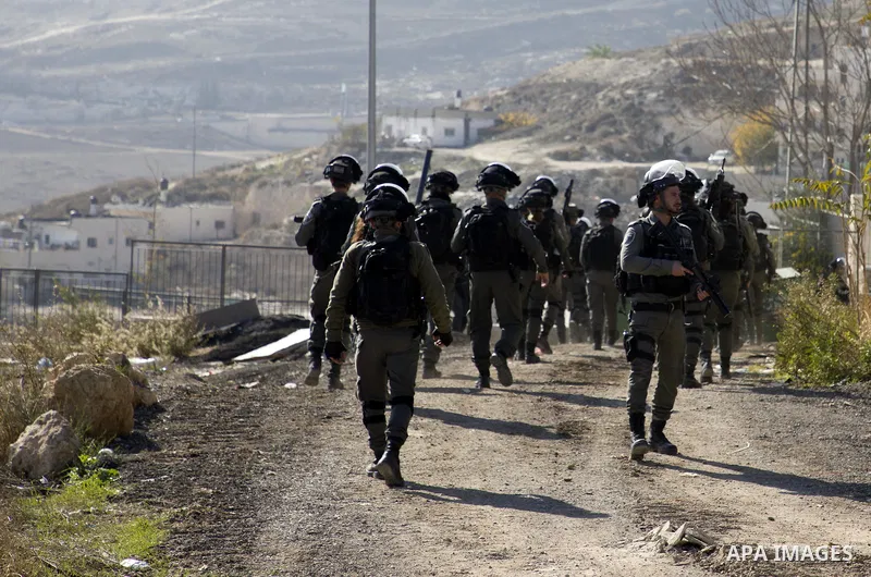 Israeli forces stand guard as an Israeli bulldozer demolishes a Palestinian building which does not have the Israeli needed permits in the neighbourhood of Issawiya, in the north of Jerusalem, on December 17, 2019. Photo...