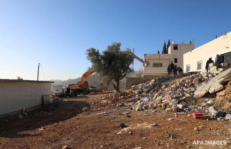 An Israeli bulldozer demolishes a Palestinian building which does not have the Israeli needed permits in the neighbourhood of Issawiya, in the north of Jerusalem, on December 17, 2019. Photo by Muhammed Qarout Idkaidek