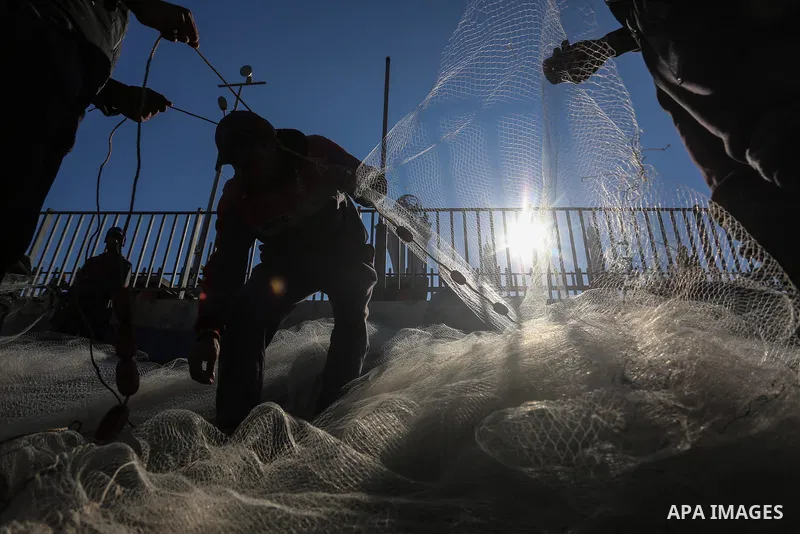 Palestinian fishermen work on their fishing boats, at Gaza seaport, on December 19, 2019. Israel decided to reduced the allowed fishing area to 10 nautical miles after it was 15 miles, in Gaza Strip. Photo by Ashraf Amra