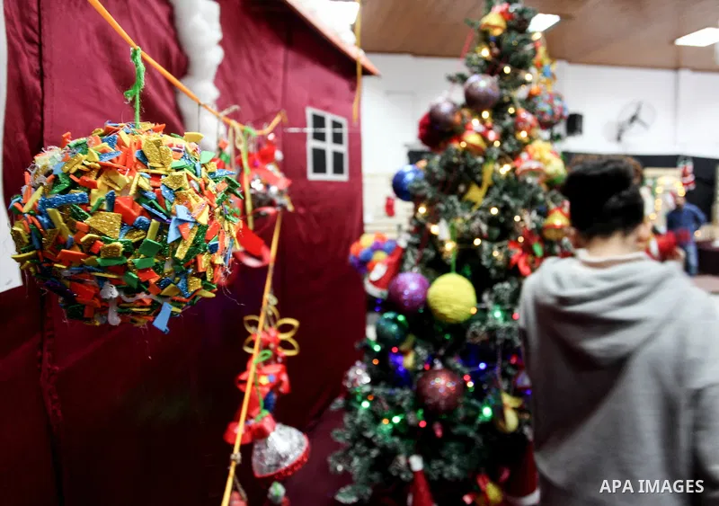 Palestinians make Christmas tree decorations from remnants of the environment, in Gaza city on December 26, 2019. Photo by Mahmoud Ajjour