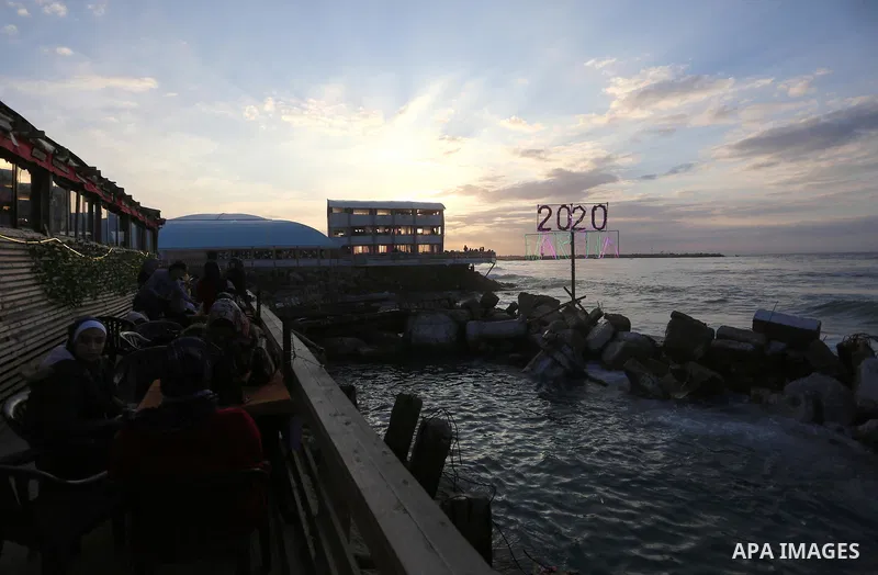 Palestinians enjoy their time on the beach during sunset in the last day of 2019, a few hours prior to the new year's celebrations, in Gaza city on December 31, 2019. Photo by Ashraf Amra