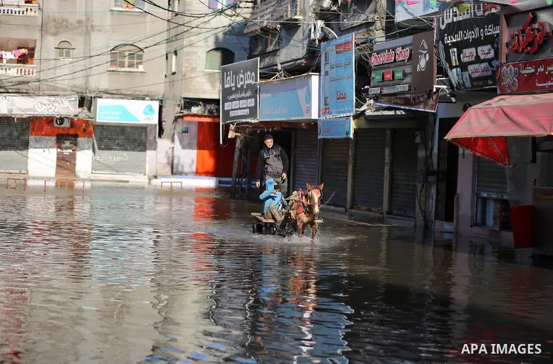 A Palestinian man rides a horse cart in a flooded street following a heavy rain in Jabaliya refugee camp, in the northern of Gaza Strip, on January 5, 2020. Photo by Ashraf Amra
