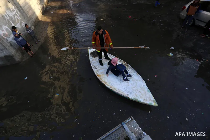 A member of Palestinian Civil Defence rides a boat as they evacuate people following heavy rain that flooded their houses in Jabaliya refugee camp, in the northern of Gaza Strip, on January 5, 2020. Photo by Ashraf Amra