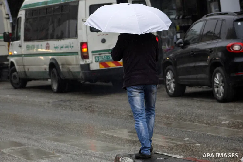 Palestinians walk in a street during a rainy day, in the West Bank city of Hebron, January 08, 2020. Photo by Mosab Shawer