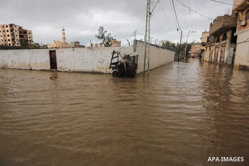 Palestinians walk in a flooded street following a heavy rain, in Gaza City on January 9, 2020. Photo by Ashraf Amra