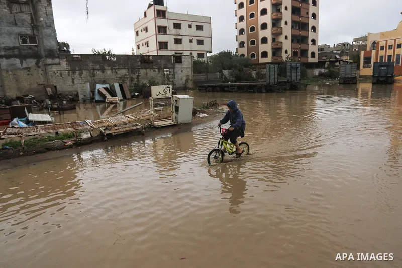 Palestinian children enjoy in a street, during a rainy day, in Gaza City, on January 09, 2020. Photo by Ashraf Amra