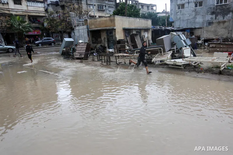 Palestinian children enjoy in a street, during a rainy day, in Gaza City, on January 09, 2020. Photo by Ashraf Amra