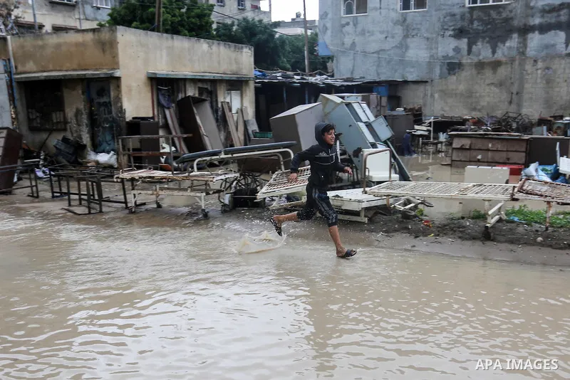 Palestinian children enjoy in a street, during a rainy day, in Gaza City, on January 09, 2020. Photo by Ashraf Amra