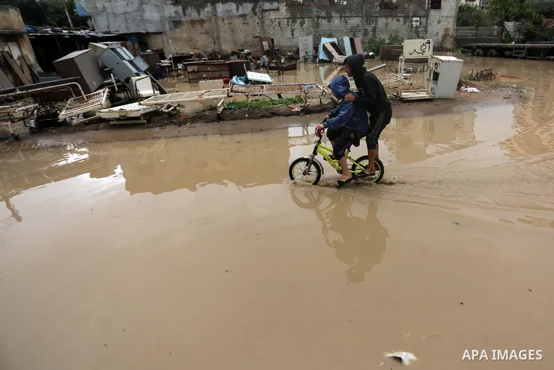 Palestinian children enjoy in a street, during a rainy day, in Gaza City, on January 09, 2020. Photo by Ashraf Amra