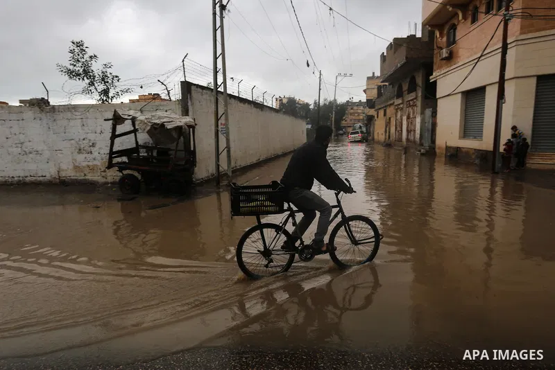 Palestinians walk in a flooded street following a heavy rain, in Gaza City on January 9, 2020. Photo by Ashraf Amra