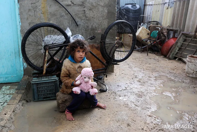 Palestinian children enjoy during a cold weather spell in an empoverished neighbourhood on the outskirts in Gaza City on January 9, 2020. Photo by Ashraf Amra