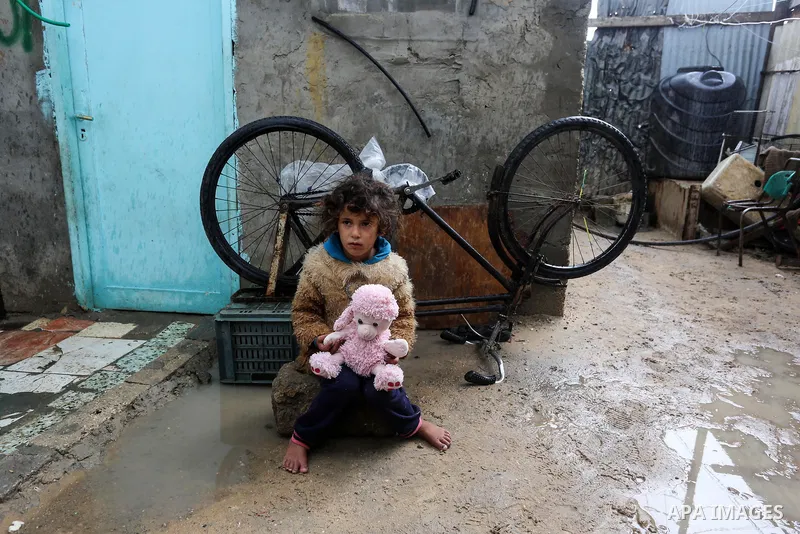 Palestinian children enjoy during a cold weather spell in an empoverished neighbourhood on the outskirts in Gaza City on January 9, 2020. Photo by Ashraf Amra