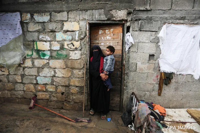 A Palestinian woman stands during a cold weather spell in an empoverished neighbourhood on the outskirts in Gaza City on January 9, 2020. Photo by Ashraf Amra