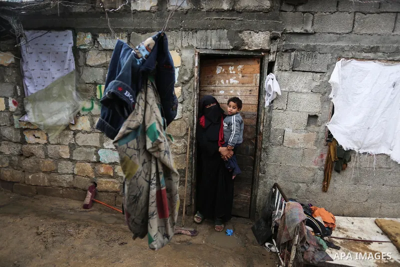 A Palestinian woman stands during a cold weather spell in an empoverished neighbourhood on the outskirts in Gaza City on January 9, 2020. Photo by Ashraf Amra