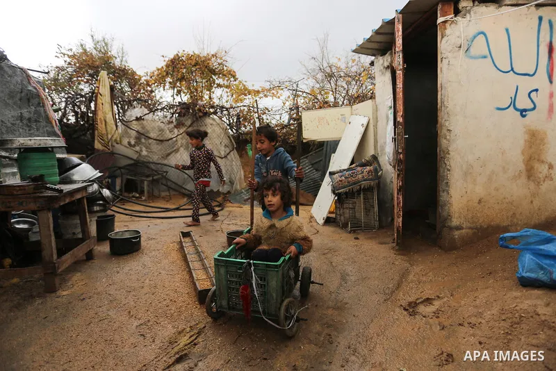 Palestinian children enjoy during a cold weather spell in an empoverished neighbourhood on the outskirts in Gaza City on January 9, 2020. Photo by Ashraf Amra