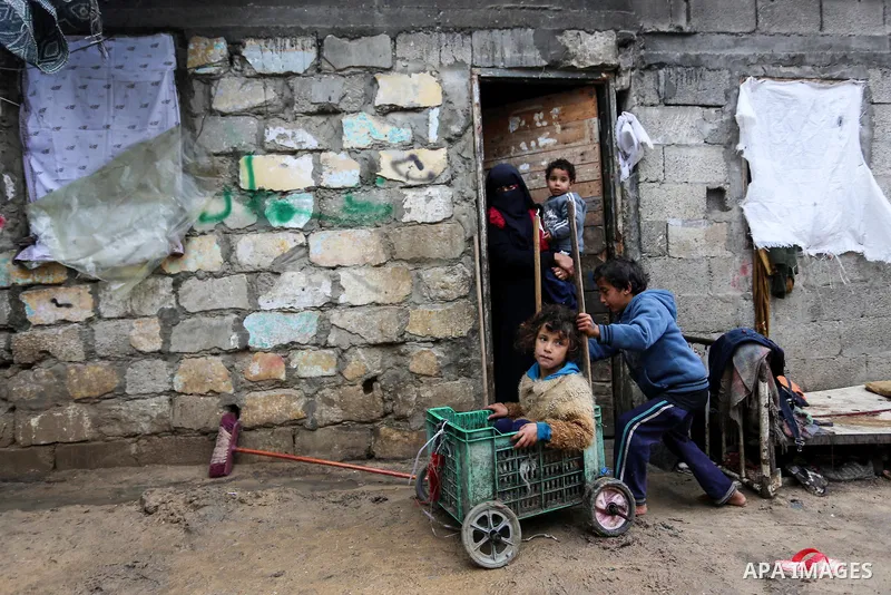 Palestinian children enjoy during a cold weather spell in an empoverished neighbourhood on the outskirts in Gaza City on January 9, 2020. Photo by Ashraf Amra