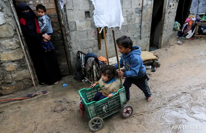 Palestinian children enjoy during a cold weather spell in an empoverished neighbourhood on the outskirts in Gaza City on January 9, 2020. Photo by Ashraf Amra