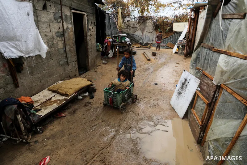 Palestinian children enjoy during a cold weather spell in an empoverished neighbourhood on the outskirts in Gaza City on January 9, 2020. Photo by Ashraf Amra
