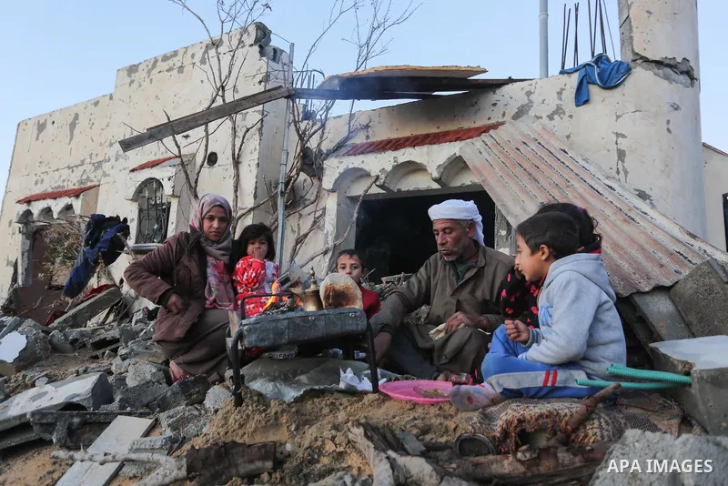 Members of a Palestinian family heat the bread outside their destroyed house, on a winter cold day, in Khan Youns southern in Gaza city January 10, 2020. Photo by Ashraf Amra