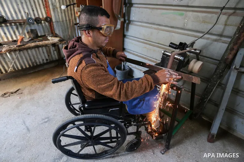 Palestinian blacksmith Jalal Abu Hayah (40), on Wheelchair-bound who became disabled during the clashes with Israeli troops along the Israel-Gaza border, makes swords and daggers, at his workshop, in Khan Younis in the s...