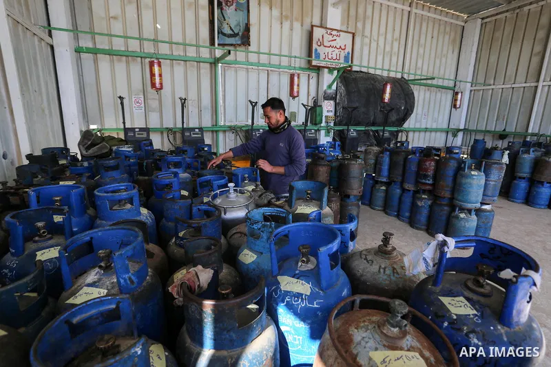 Palestinians wait near of the empty gas canisters at a natural gas station in Rafah in the southern Gaza Strip on January 21, 2020. The Gaza Strip is facing a gas crisis over the past few days due to the continued blocka...