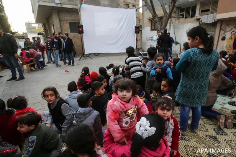 Palestinian children watch a movie during an event called "Cinema Camp" organised by Palestinian activists in al-Nusirat refugee camp in the central Gaza strip on January 27, 2020. Photo by Ashraf Amra