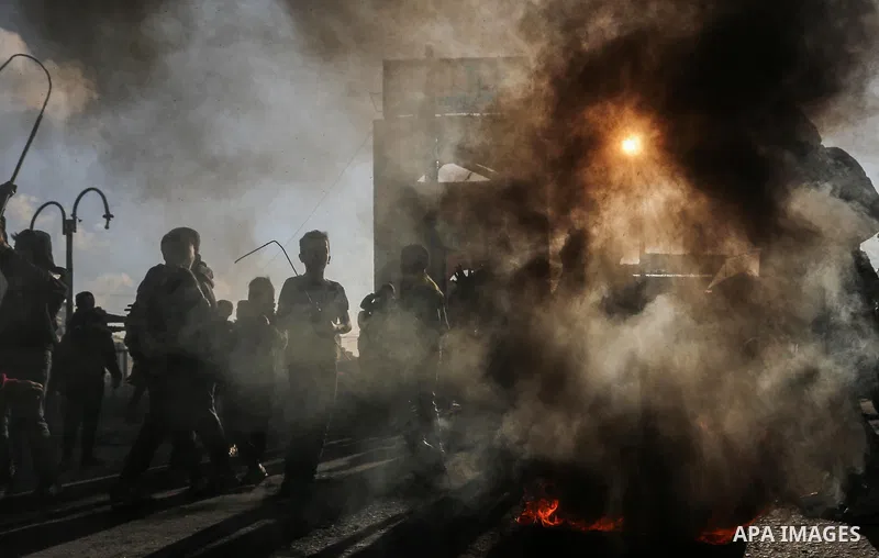 Palestinian demonstrators burn tyres during a protest against US President Donald Trump's Century Deal "expected peace plan" in Rafah in the southern Gaza Strip on January 29, 2020. Donald Trump has launched his “ultimat...