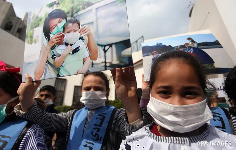 Palestinian childern take part in a rally to support with people in China suffering from the Corona virus, in Gaza city, on February 16, 2020. China has more than 80 running or pending clinical trials on potential treatm...