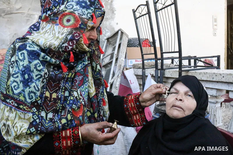 A Palestinian Hadia Qudaih 70, puts a traditional eye cosmetic "Arab kohl or Black eyeliner" in the eye of a woman at her home in Khan Younis in the southern of Gaza strip, on February 17, 2020. Eye liner or eyeliner is...