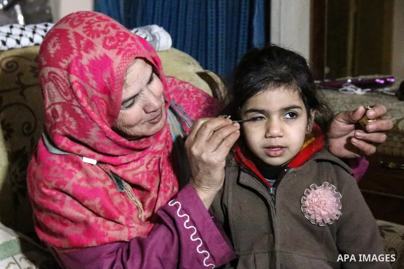 A Palestinian woman Hadia Qudaih 70, puts a traditional eye cosmetic "Arab kohl or Black eyeliner" in the eye of a girl at her home in Khan Younis in the southern of Gaza strip, on February 17, 2020. Eye liner or eyeline...